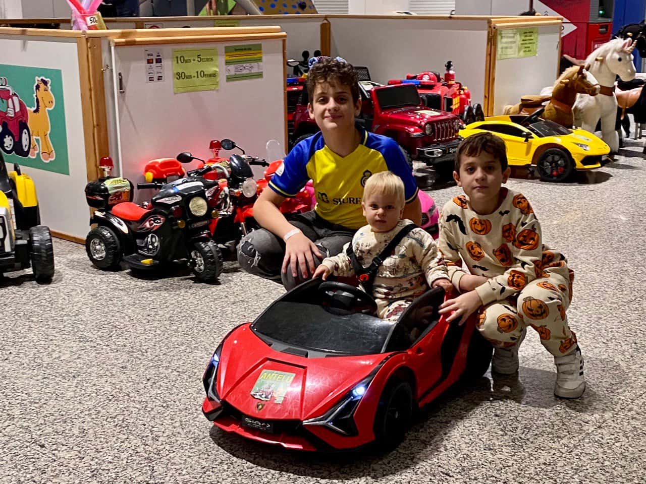 Unha familia xunto a un coche infantil vermello en Antelu