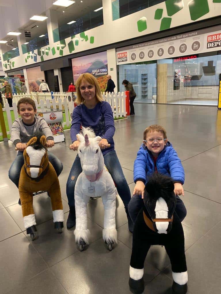 Unha familia gozando de tres cabaliños no centro comercial