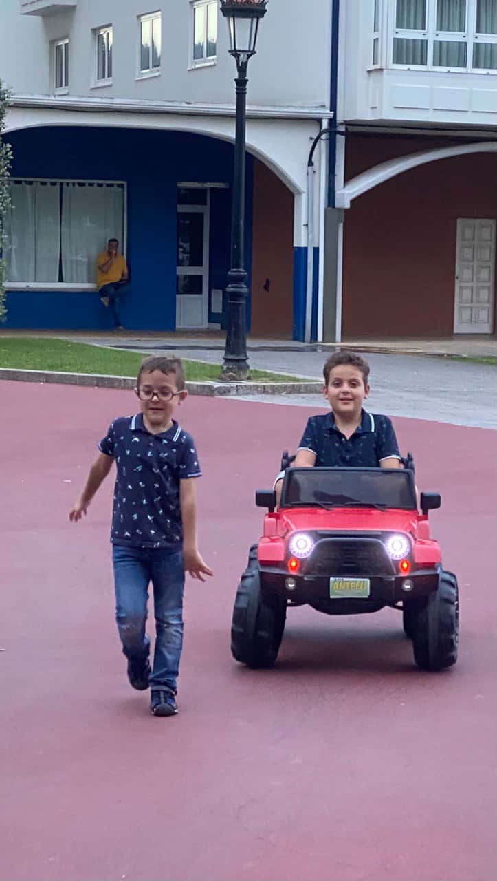 Dous nenos paseando nun todoterreo vermello